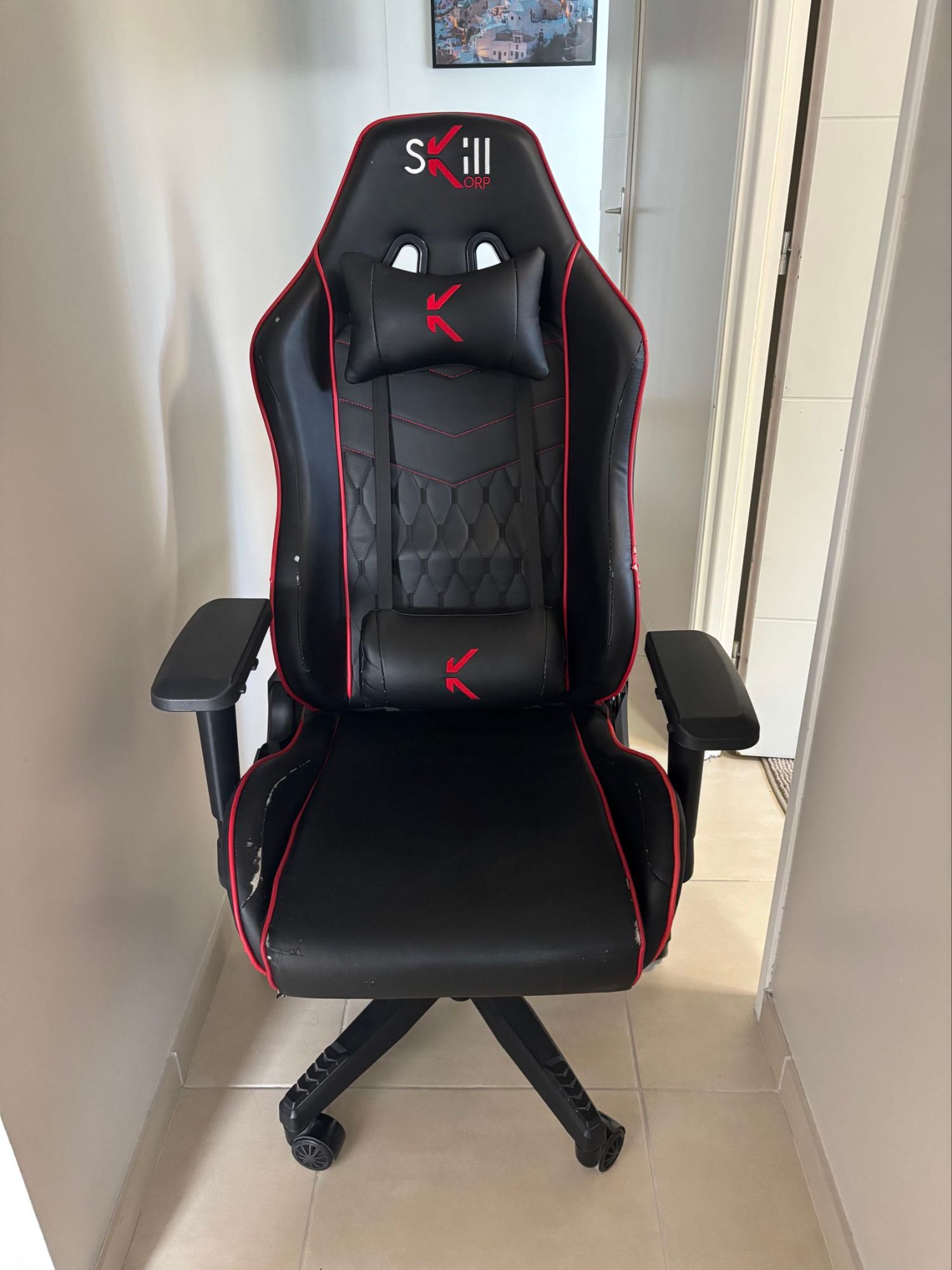 Chaise gaming Skillkorp. Couleur noir et rouge. En bon état. Deux coussins lombaires et tête. Repose bras ajustable de 3 façon différente hauteur largeur profondeur. Inclinaison et balancier. Top !!!